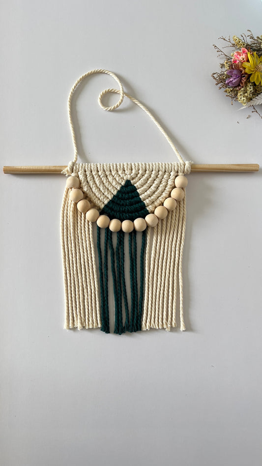 Macrame wall hanging with geometric design on a plain background